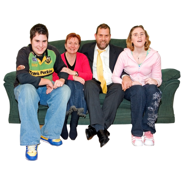 Four people sitting on a green sofa, smiling.