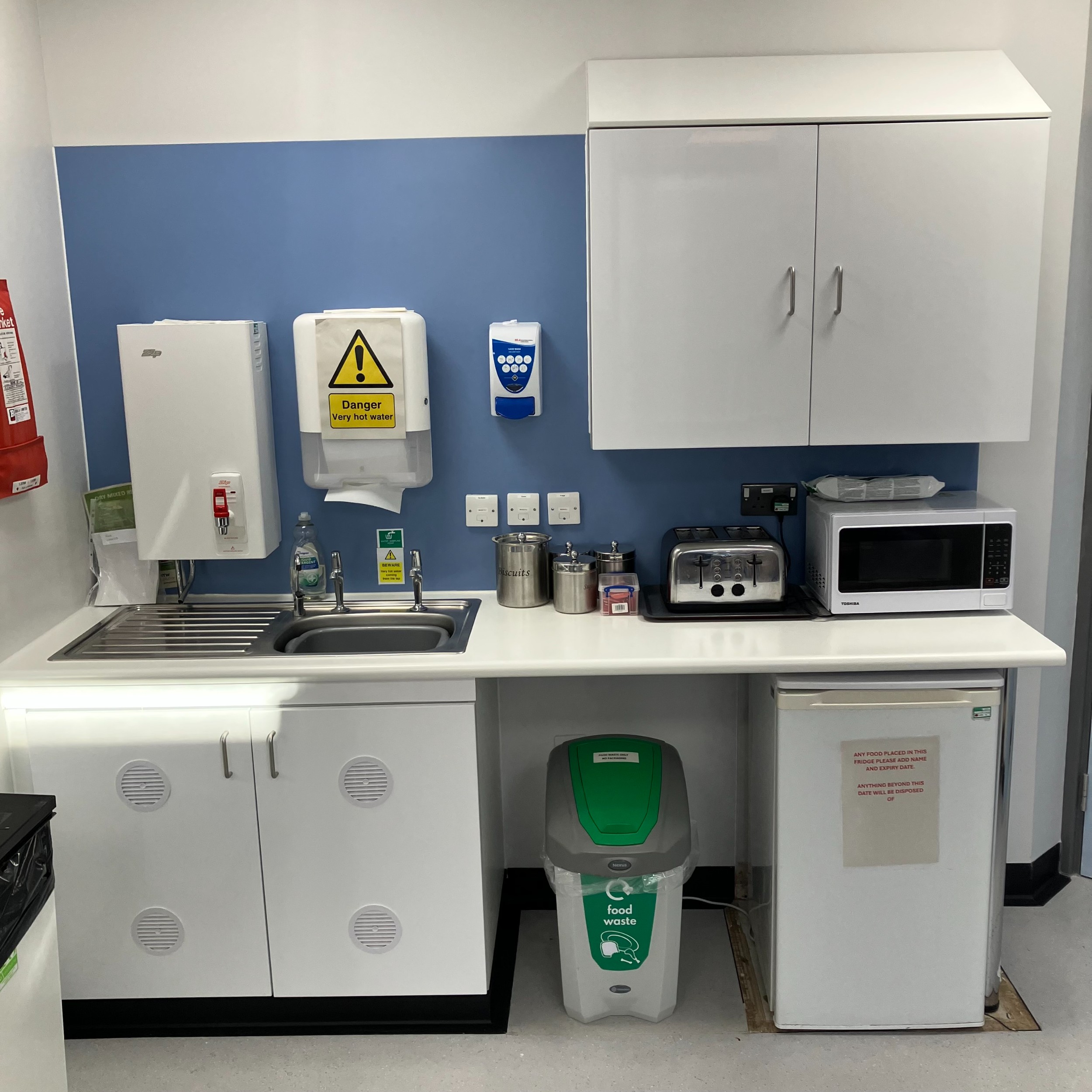 Kitchen area with white cabinets and utilities