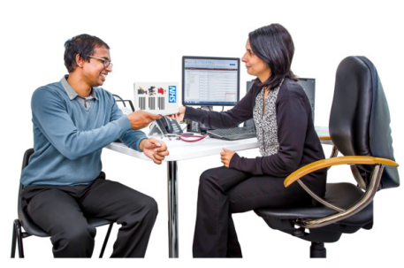 A woman at her office desk talking with a man