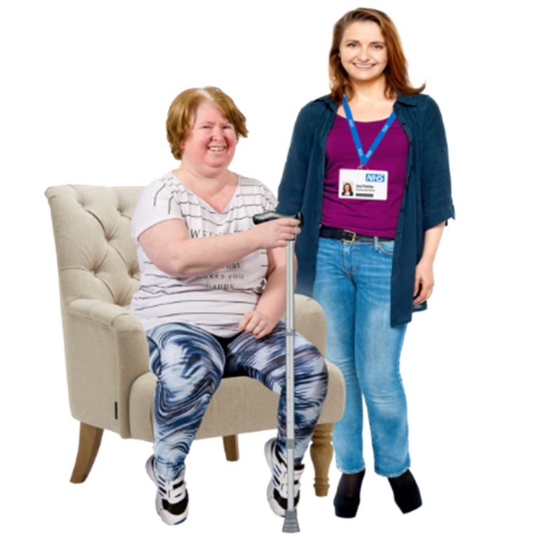 A woman sitting in a chair and holding a walking stick. Next to her is a staff member with her ID on show.