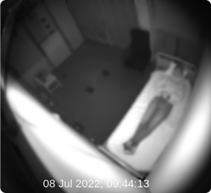 A blurred image of a person lying on a hospital bed