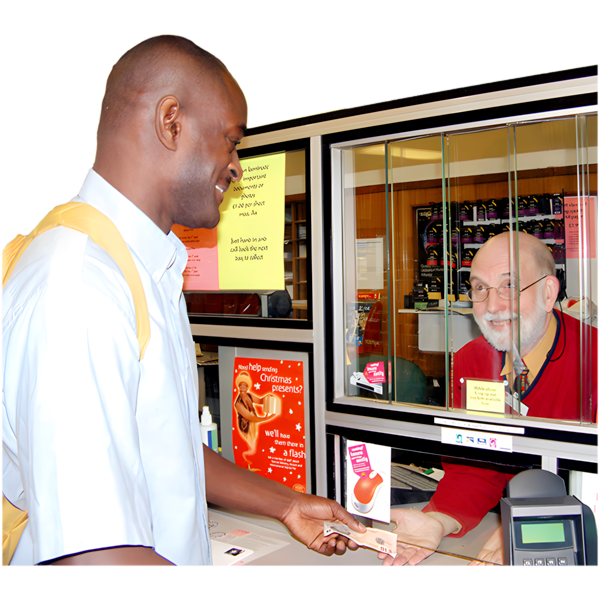 A person handing money to a person behind the finance counter