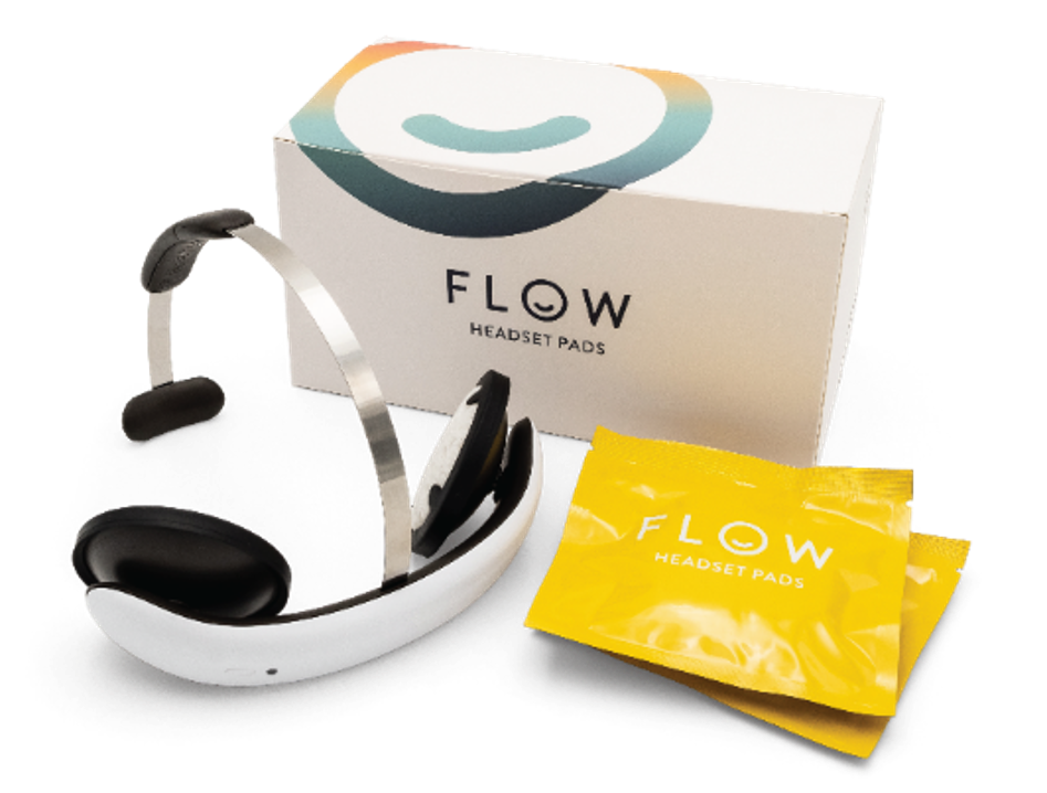 A white box with black and white headphones and 2 yellow packets with wipes