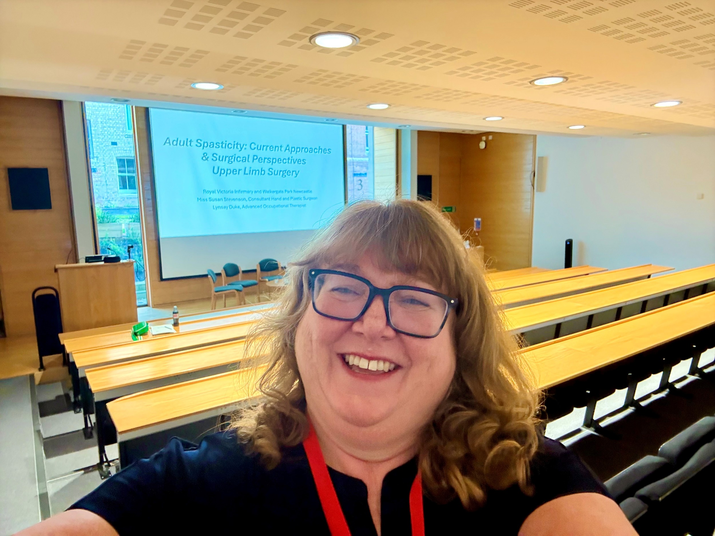 woman smiling taking a selfie in a lecture theatre