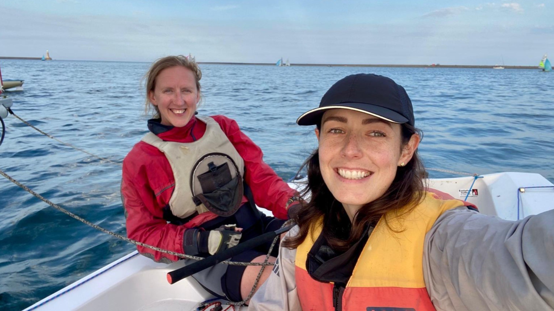 Two people smiling at camera on a boat