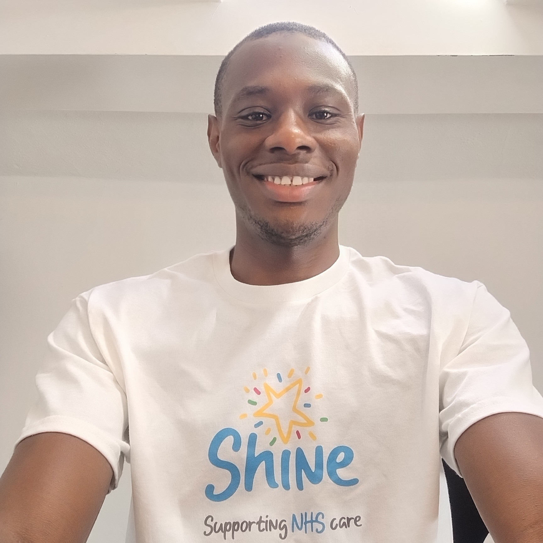 Man smiling at camera wearing a white t-shirt