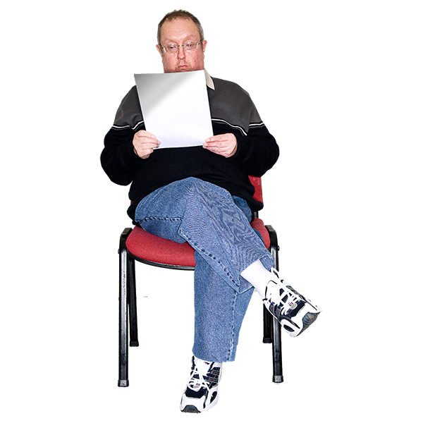 Man sitting on a chair reading a piece of paper.