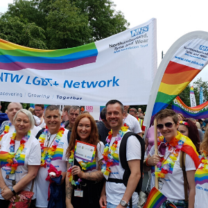 Members of the CNTW LGBT+ Staff Network at last year’s Newcastle Pride event. They are wearing lots of rainbow accessories and holding a CNTW LGBT+ Network banner.