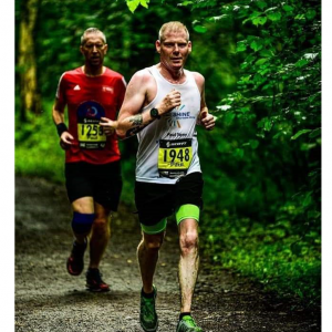 Paul Sams running in a race through woodland