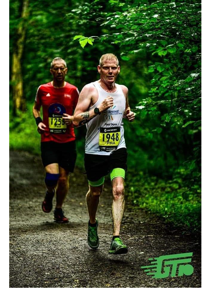 Paul Sams running in a race through woodland