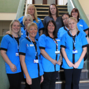 The 'reach out' delirium service team - nine people stood together on steps in blue uniforms