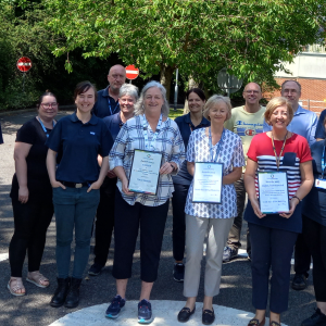 The Drive Mobility team stood outside, on the test driving track, holding the award certificates.