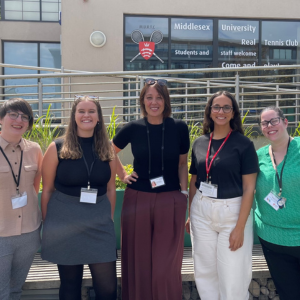 Five women standing in front of a building