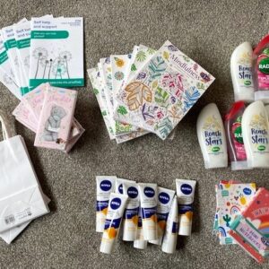 Image of gift bags, leaflets, chocolate bars, colouring books, hand cream, shower gel and notebooks.