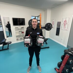 Member of staff holding new boxing equipment