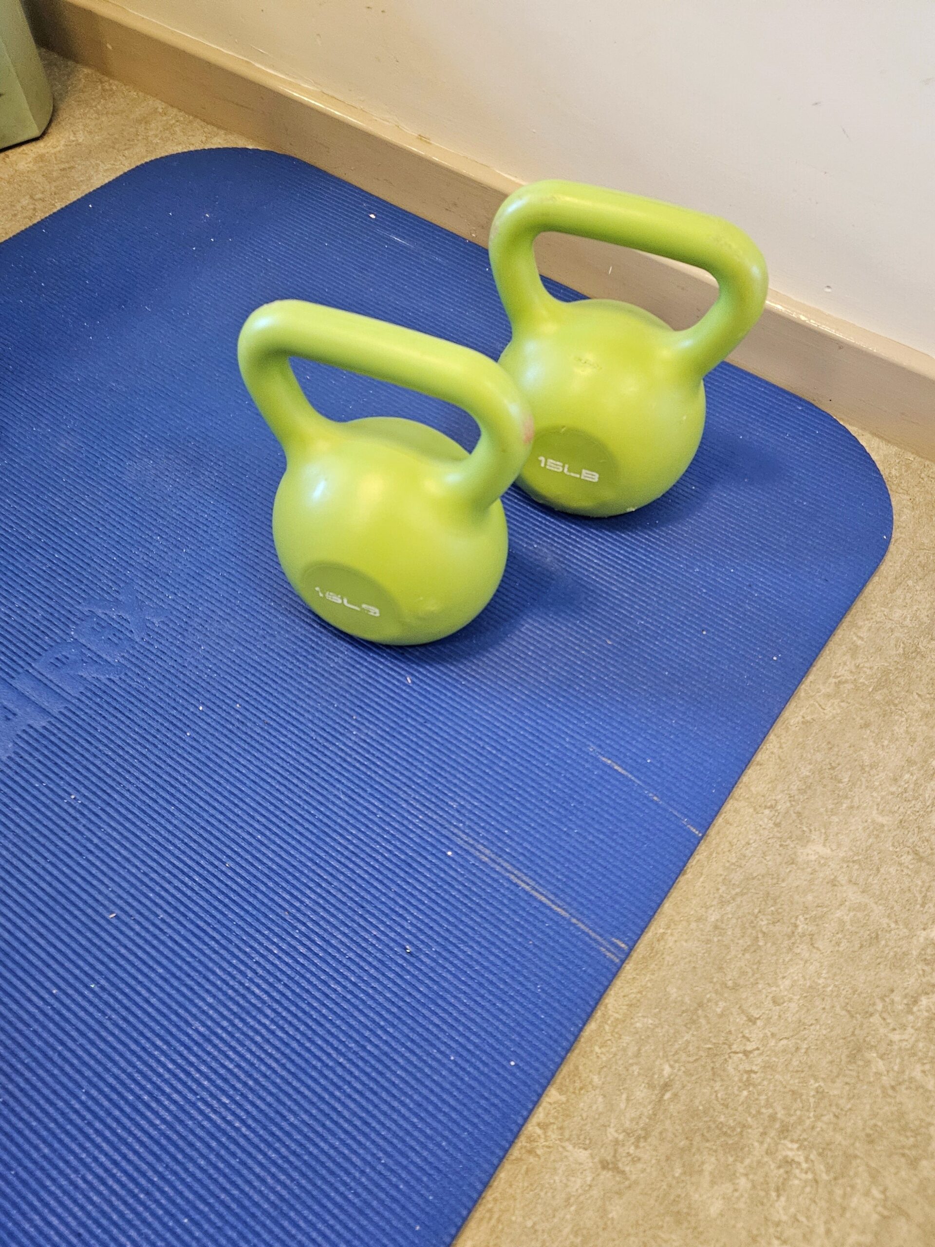 Two kettlebells on a yoga mat