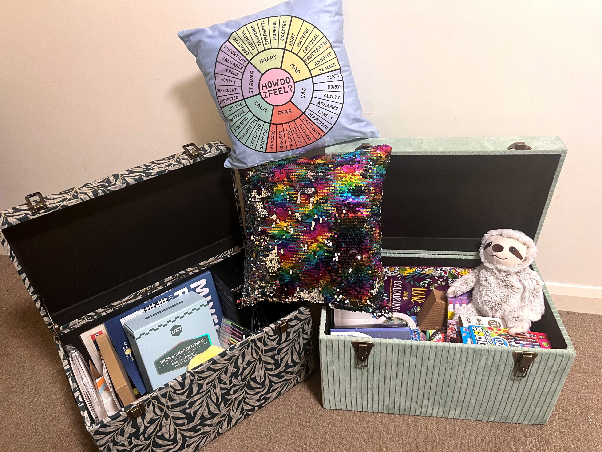 Two boxes containing sensory items such as puzzle books, scented markets, plush toys and more