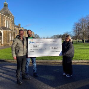 Paul, Mohammed and charity Marketing Manager Daria holding a large cheque donation