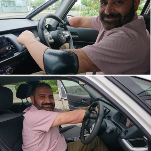 Asif Hussain sitting in the driver's seat of a car with an adapted steering wheel